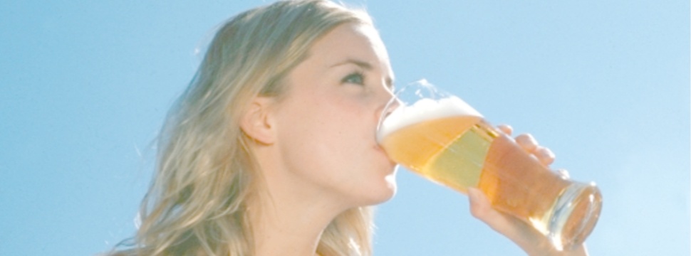 Eine Frau trinkt ein alkoholfreies Bier