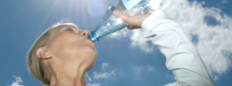 A woman is drinking mineral water